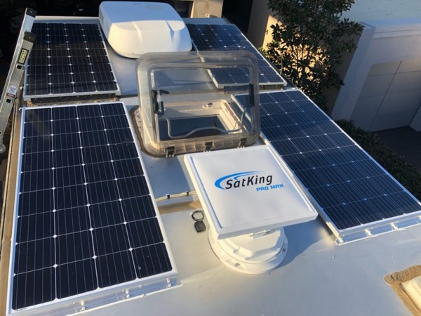 Crowded caravan roof with solar panels and rooftop fittings